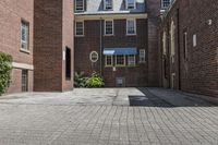 an empty brick alley with a fire hydrant next to it and buildings behind it