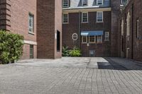 an empty brick alley with a fire hydrant next to it and buildings behind it