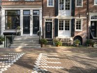 a black and white checkered pavement that is outside a building, with blue shutters