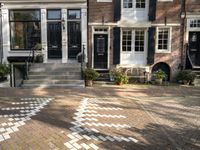 a black and white checkered pavement that is outside a building, with blue shutters