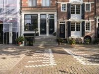 a black and white checkered pavement that is outside a building, with blue shutters