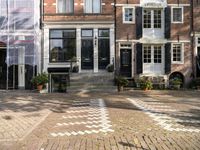 the front door to an old house with brick steps and potted plants outside of them