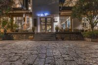 a small restaurant on the corner of an old town street, at night, with lights