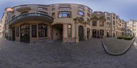 a 360 view of an ornate building in the middle of a small town street by itself