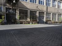 a row of wooden benches on a city street next to a building with many windows