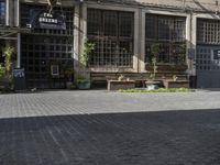 a row of wooden benches on a city street next to a building with many windows