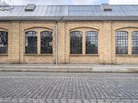 the outside of an old brick building is very large and it has two tall windows