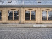 the outside of an old brick building is very large and it has two tall windows