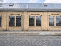 the outside of an old brick building is very large and it has two tall windows