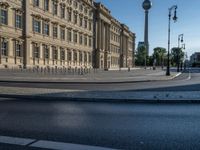 a street light next to an empty road in front of a building with a traffic light on top of it