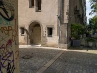 a door is shown on a building near a potted planter with graffiti all over it