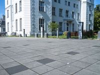 a building has multiple decorative post, in front of it and several bicycles parked around