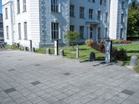 a building has multiple decorative post, in front of it and several bicycles parked around