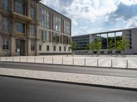 this is an outdoor area near buildings with glass windows on the sides, surrounded by a row of metal fences