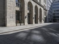 the entrance to a building on a street in front of buildings with arches on either side of it