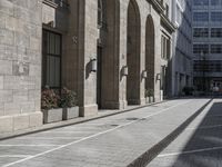 the entrance to a building on a street in front of buildings with arches on either side of it