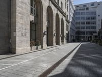 the entrance to a building on a street in front of buildings with arches on either side of it