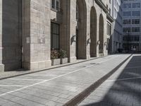 the entrance to a building on a street in front of buildings with arches on either side of it