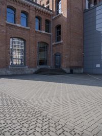 a brick walkway next to some buildings in the middle of town area, with text written in them