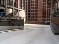 some stairs are near an empty ramp in front of buildings and some buildings near one another