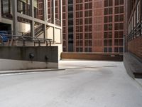 some stairs are near an empty ramp in front of buildings and some buildings near one another