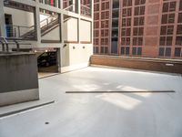 a car parked in a parking garage on a concrete surface, with a ramp and stairs visible