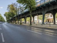 a bicycle is driving on a street and a bridge can be seen in the distance