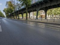 a bicycle is driving on a street and a bridge can be seen in the distance