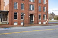 a stop sign on the street corner in front of two story brick building with multiple levels and windows