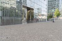 a building that has a bunch of rocks on the ground in front of it near a sidewalk