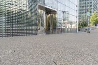 a building that has a bunch of rocks on the ground in front of it near a sidewalk