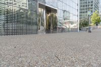 a building that has a bunch of rocks on the ground in front of it near a sidewalk