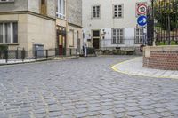 there is an old building in the background and a street sign for the street in front