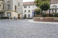 there is an old building in the background and a street sign for the street in front
