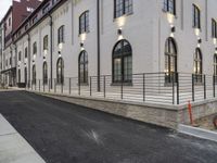 the bicycle is leaning against the wall on the road near the building in front of the bicycle rack