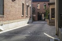 the brick walkways leading to the building have an arched window and light on them