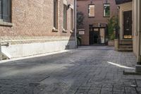 the brick walkways leading to the building have an arched window and light on them