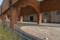 the empty courtyard area in this building features a red brick wall and arched arches that span the length of the front door