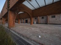 the empty courtyard area in this building features a red brick wall and arched arches that span the length of the front door