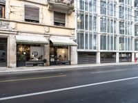 there is a picture of an empty city street in front of a tall building with open doors