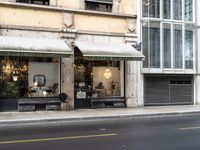 there is a picture of an empty city street in front of a tall building with open doors