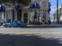 people are walking down the road near a store with blue and white awnings