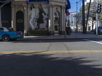 people are walking down the road near a store with blue and white awnings