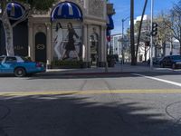 people are walking down the road near a store with blue and white awnings