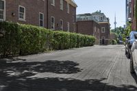 an empty street in the middle of a city with a car parked next to it