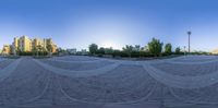 a camera lens captures the reflection of a beautiful city skyline, a curved stone plaza with lots of buildings