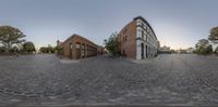 a fish eye view of two buildings in a large city street with cobblestones