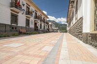 a long brick street with a line of buildings with arches in them and a sidewalk with tiles in front