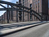 a picture taken of an empty street in a city with tall buildings and a bridge