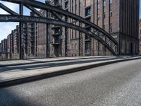 a picture taken of an empty street in a city with tall buildings and a bridge